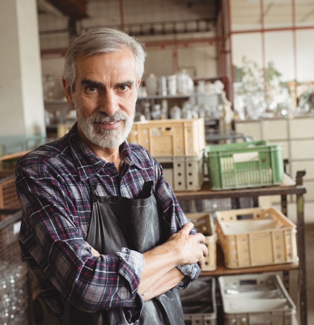 Business owner crossing arms standing in
        kitchen