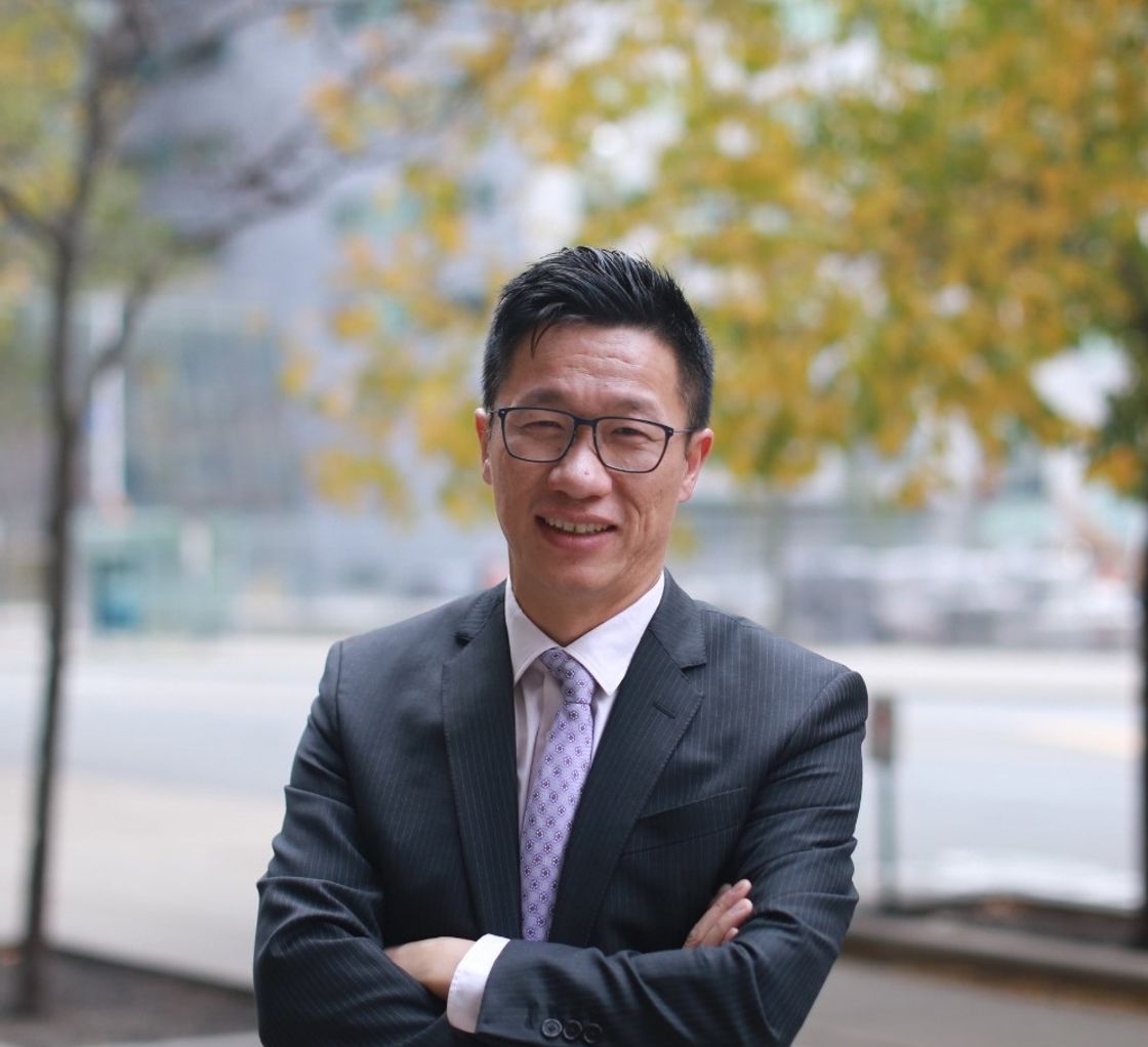 Jobi Wong sitting at desk doing financial
        planning